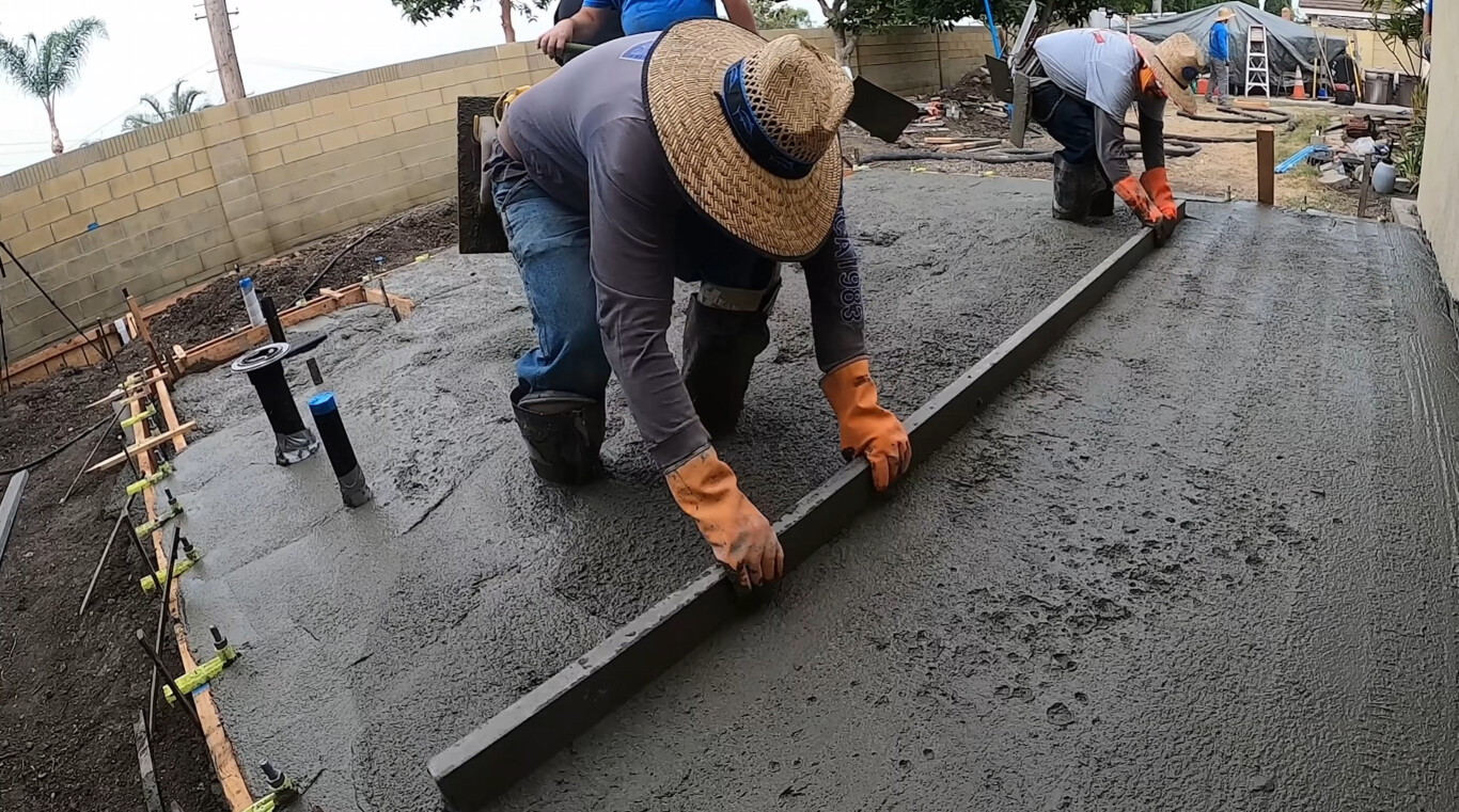 Professional concrete contractors finishing a concrete slab in Redlands, CA